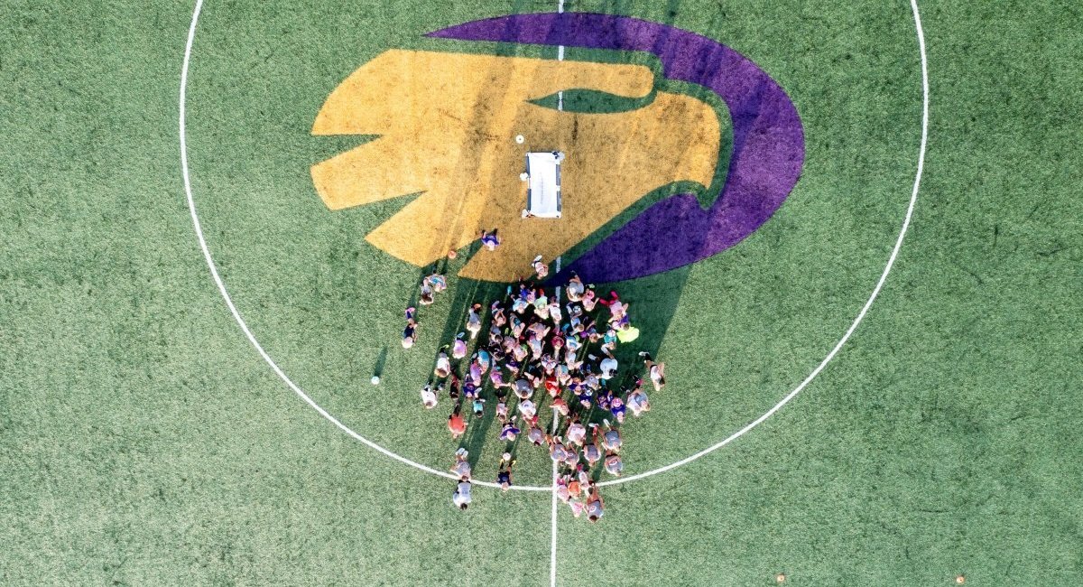 A bird's-eye view of a group of children gathered on a field at Junior Golden Eagles camp