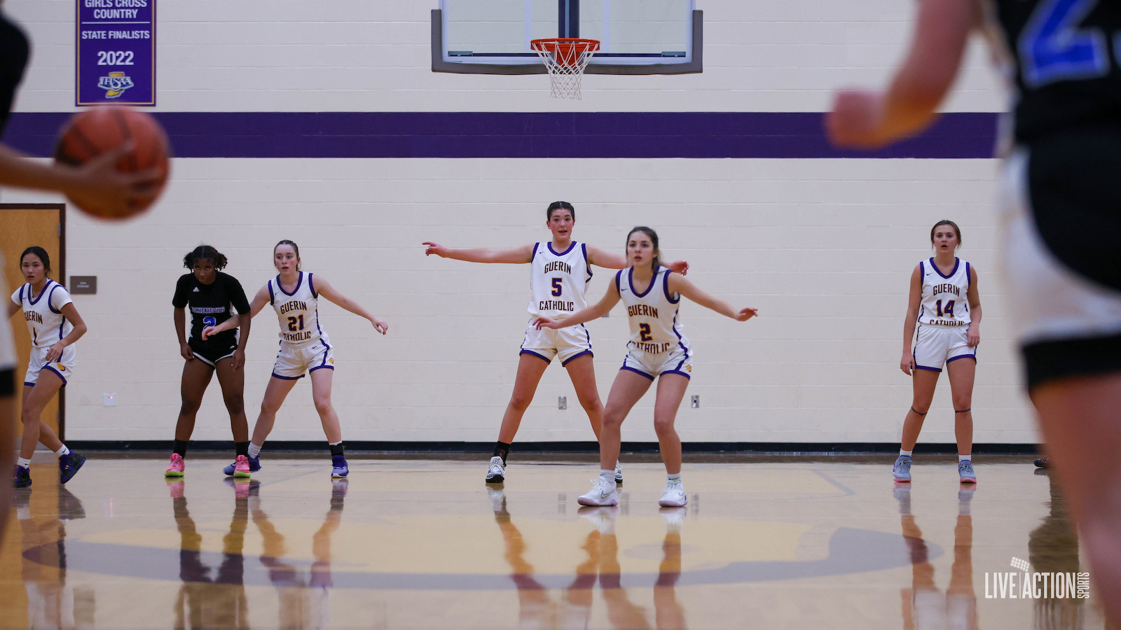 Junior Golden Eagles girls' basketball team in white and purple uniforms on the court