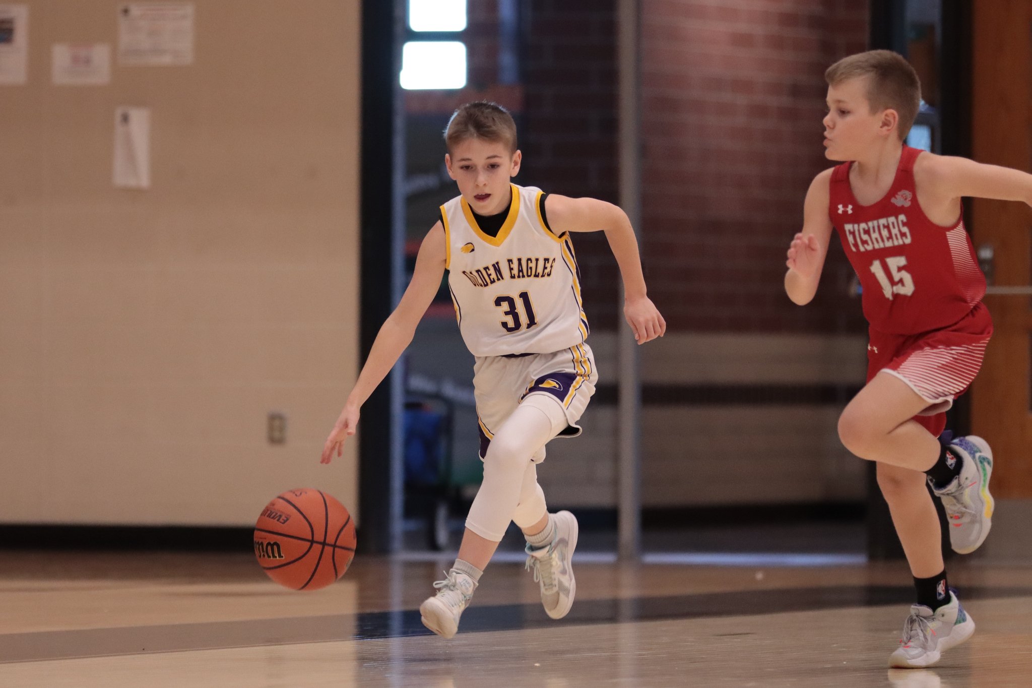Junior Golden Eagles boys playing basketball indoors